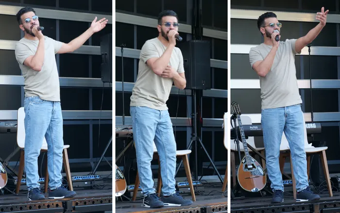 Sänger Lorenzo Sposato performt auf der Bühne des Sommerfestes in Herscheid. Er trägt ein beiges T-Shirt, Jeans und dunkle Schuhe und singt in ein Mikrofon.